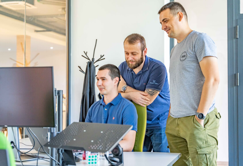 team members looking at Mac, smiling