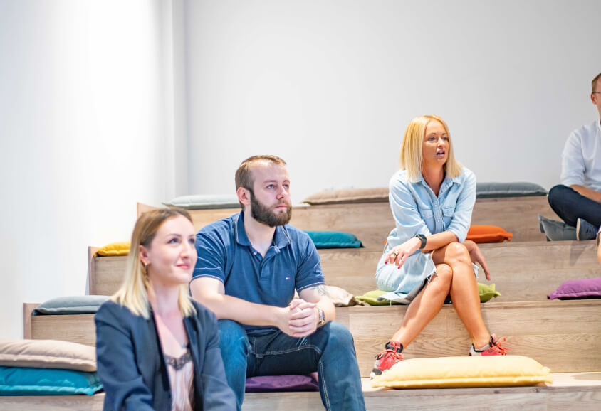 ProductDock team listening while sitting down on colorful pillows